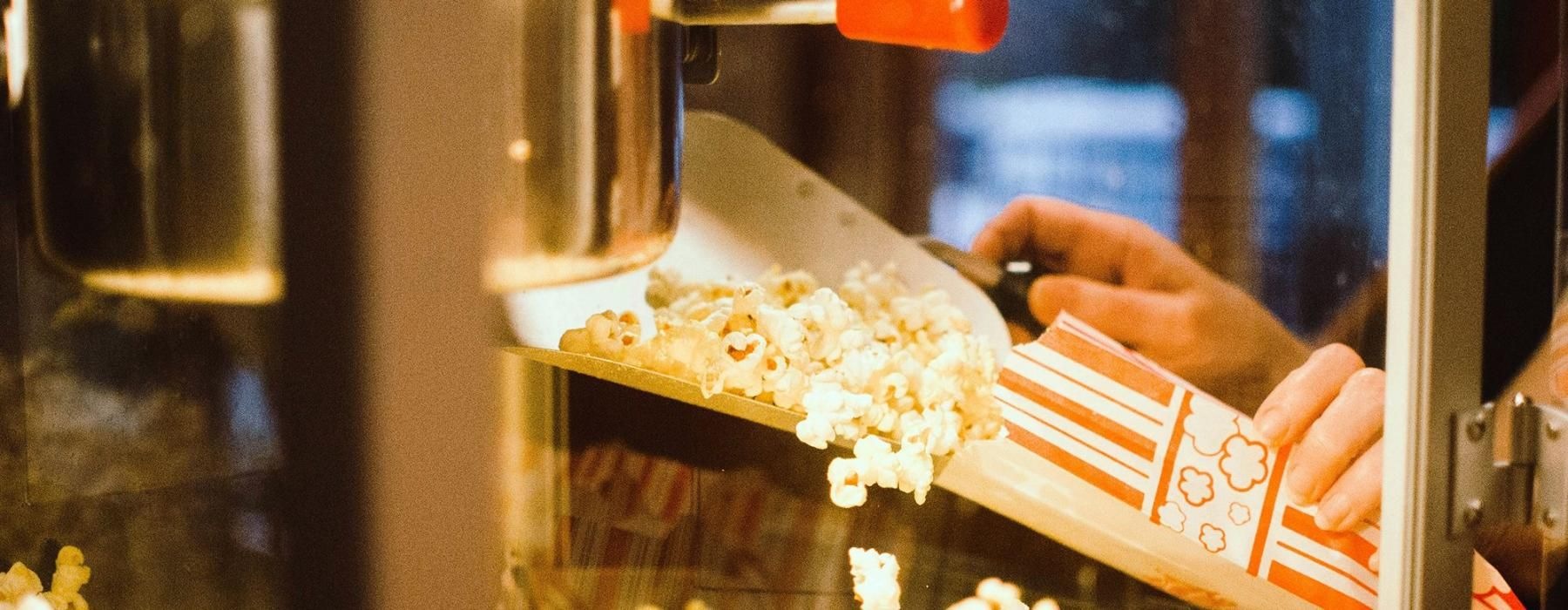 a person pouring popcorn into a container